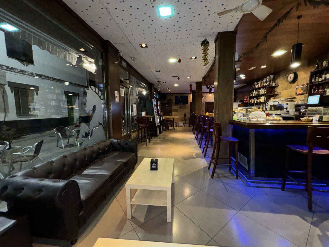 Salón del Bar Orly con sofá de cuero y mesas bajas